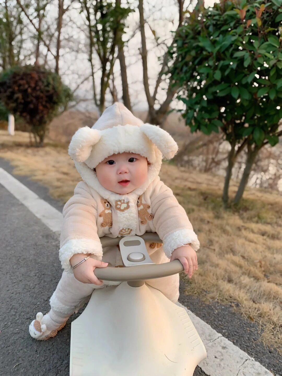 Bé mang đồ len ấm áp đang đi dạo cùng mẹ trên con xe của mình.