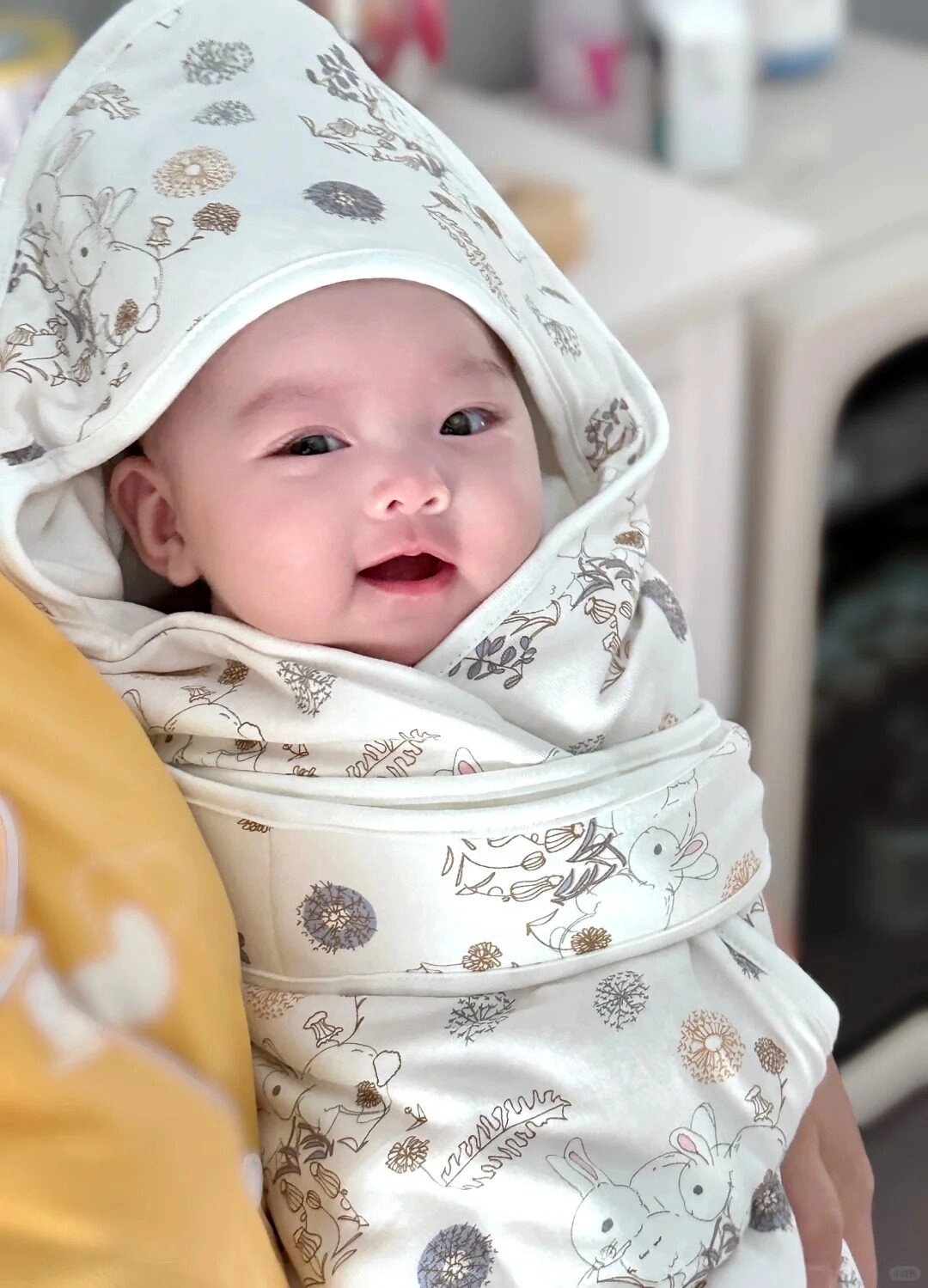 Khuôn mặt đáng yêu lấp ló dưới chiếc khăn mềm họa tiết thỏ tinh nghịch.