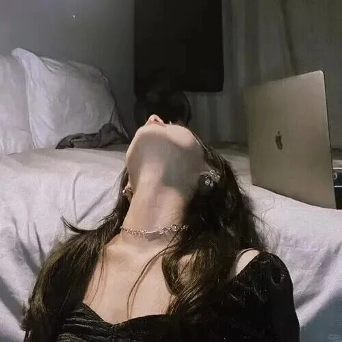 Cô gái tựa đầu vào góc giường ngủ, ánh mắt xa xăm đầy những suy tư.