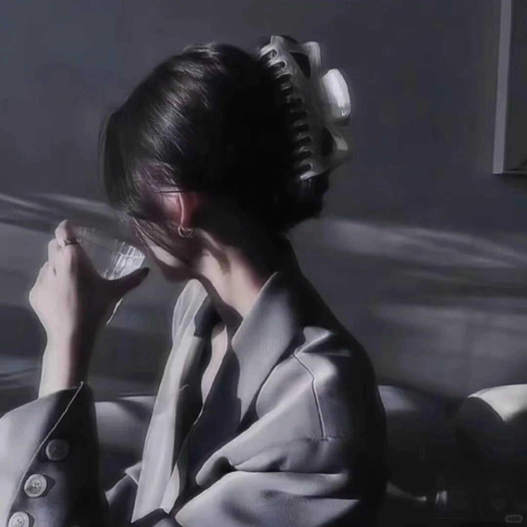 Khoác lên mình chiếc ves công sở cô gái cầm li rượu quay mặt đi như né tránh nỗi buồn.