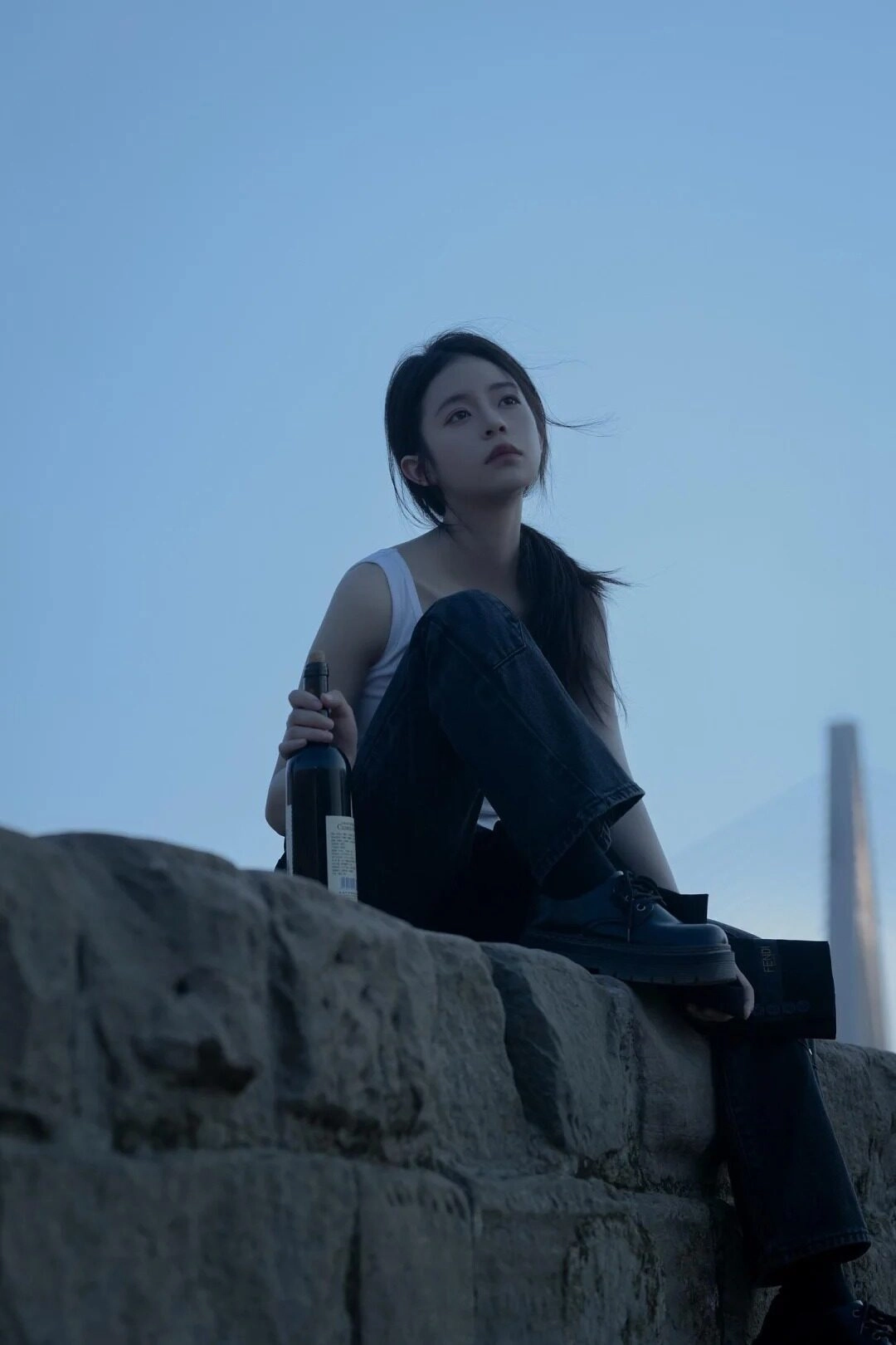 Cô gái thất tình bên chai rượu vang ngồi ngoài bãi đá.