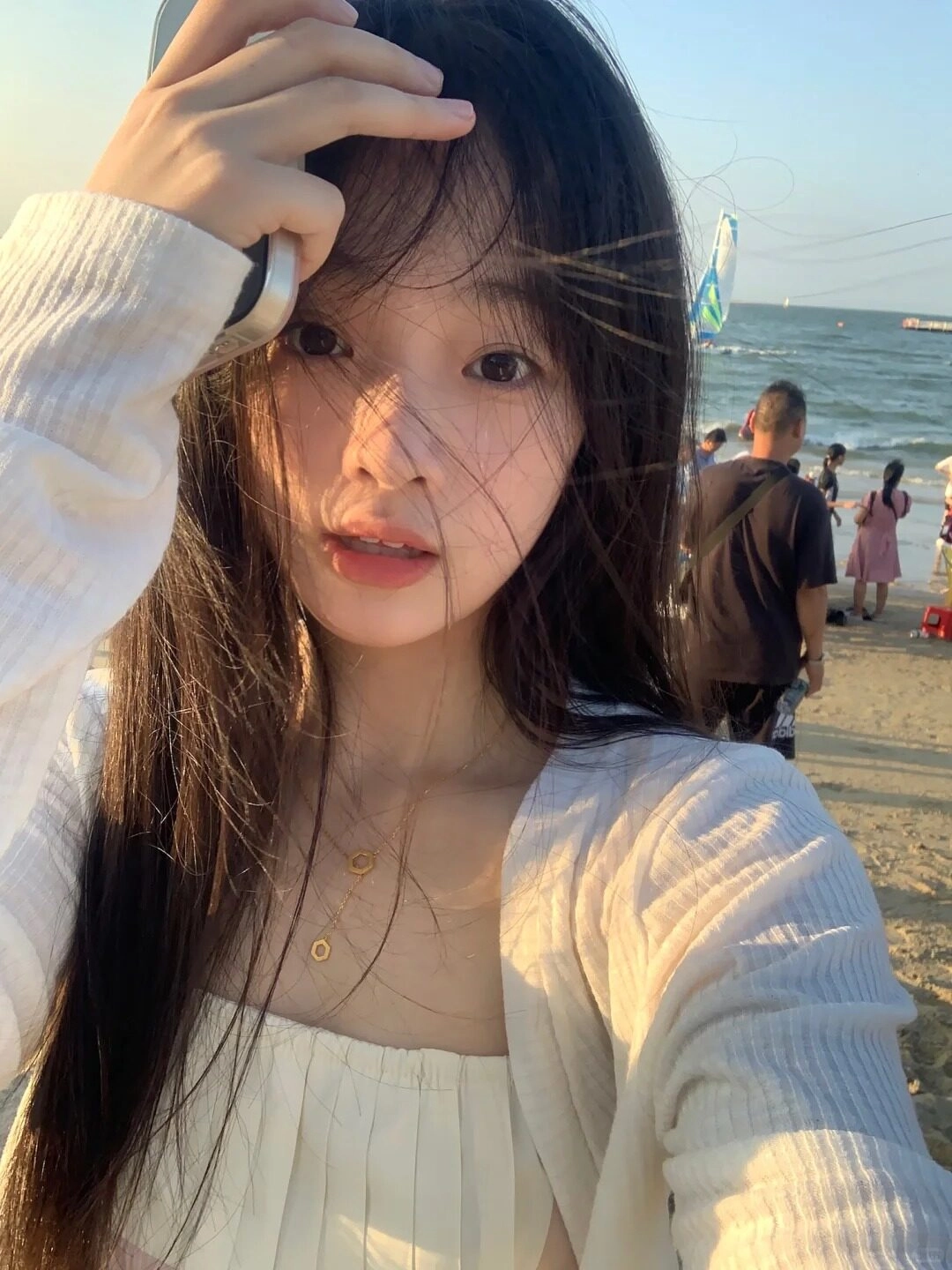 Ánh hoàng hôn rực rỡ trên bãi biển, mái tóc bay lãng mạn trong làn gió chiều thư thái.