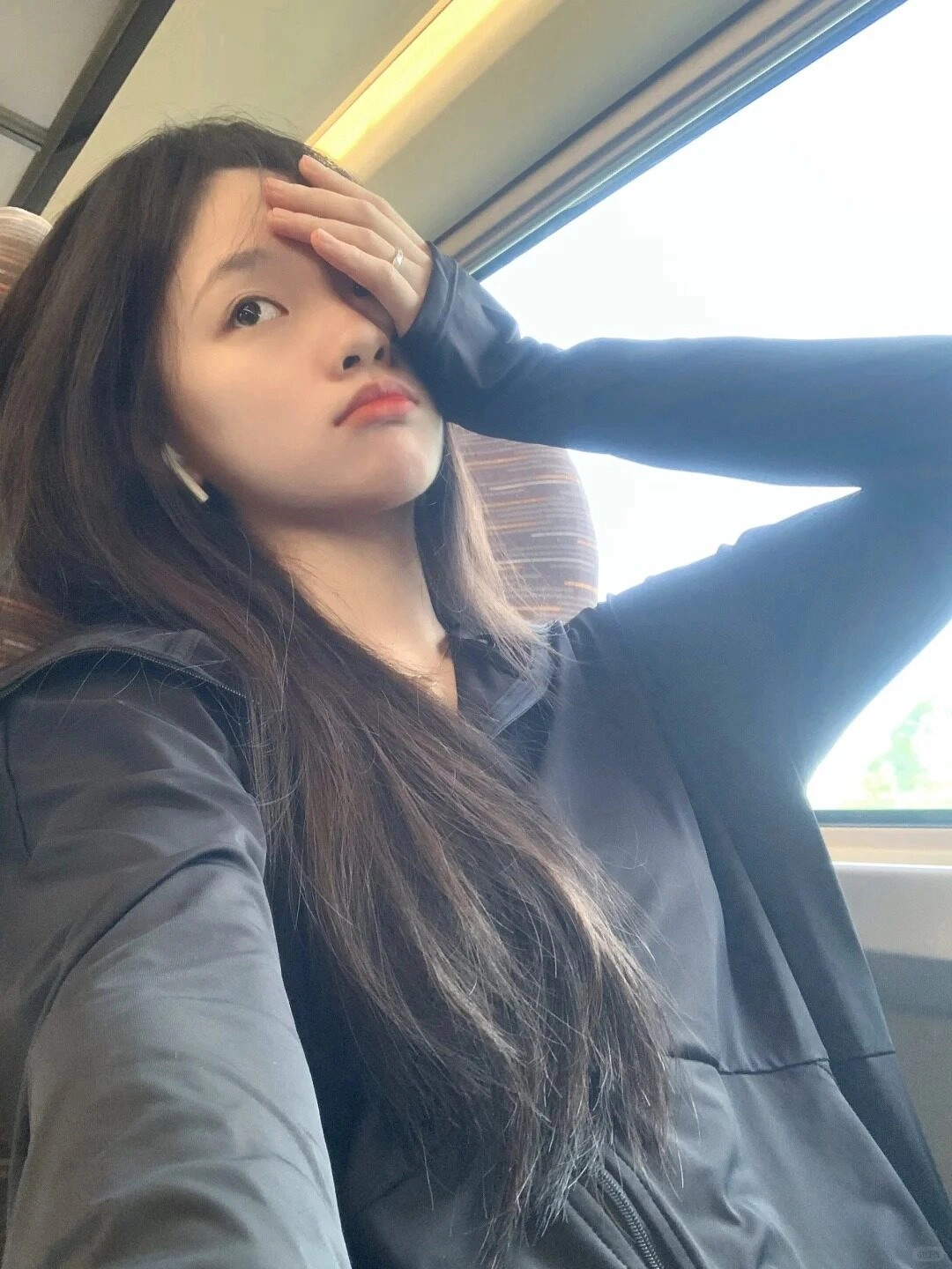 Áo khoác đen cá tính, bàn tay che mắt, ánh mắt trầm tư trên tàu.