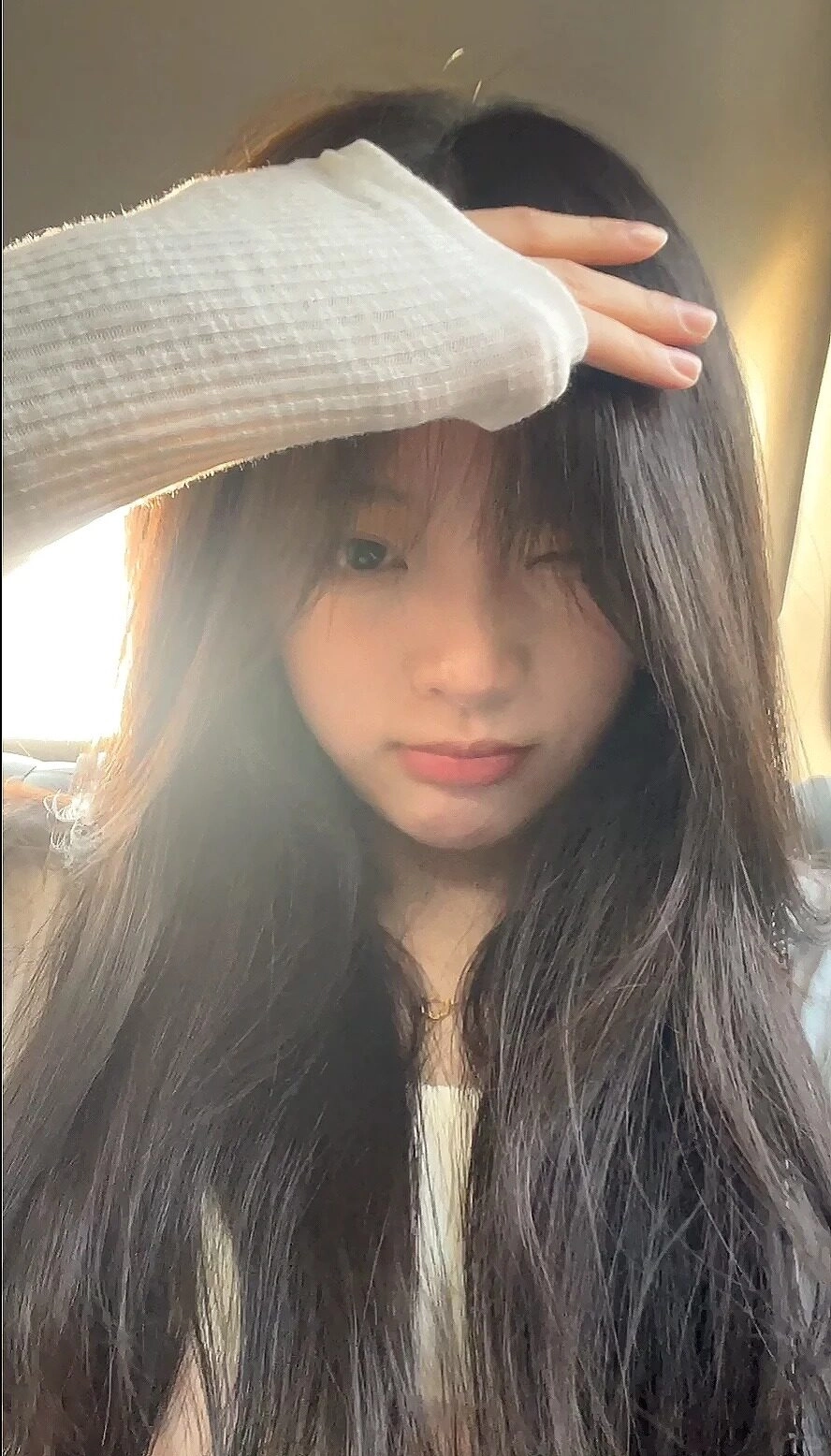 Tóc dài bồng bềnh, ánh nắng chiếu xuyên, bàn tay che nắng đầy tự nhiên.