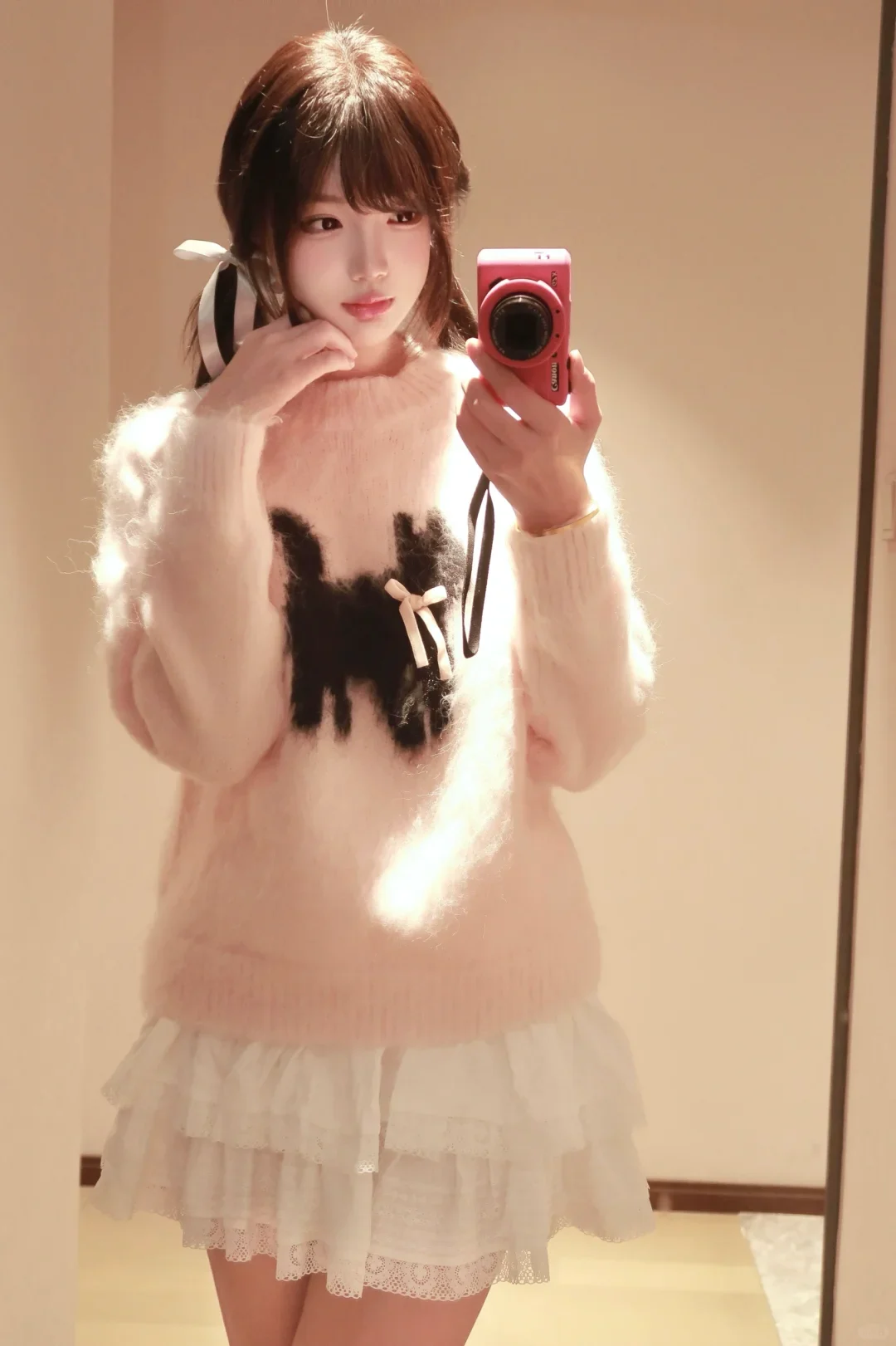 Áo len hồng mềm mại, ánh đèn lung linh, ánh mắt dịu dàng đầy sức hút.