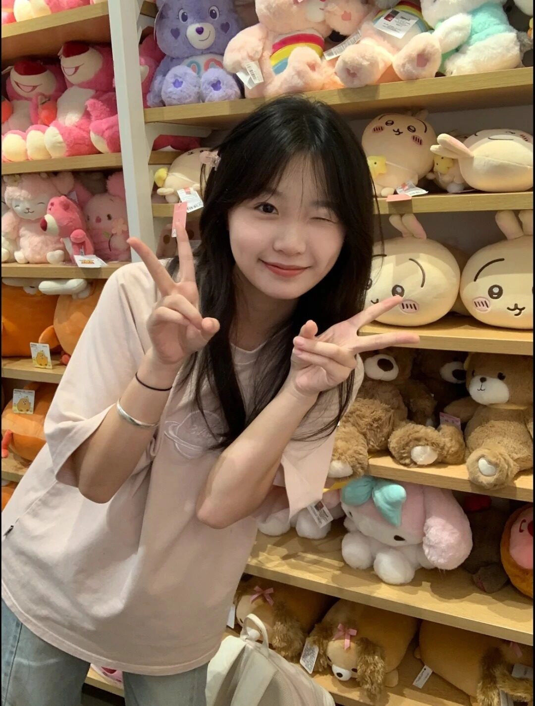 Giơ tay tạo dáng dễ thương giữa thế giới gấu bông đầy sắc màu đáng yêu.