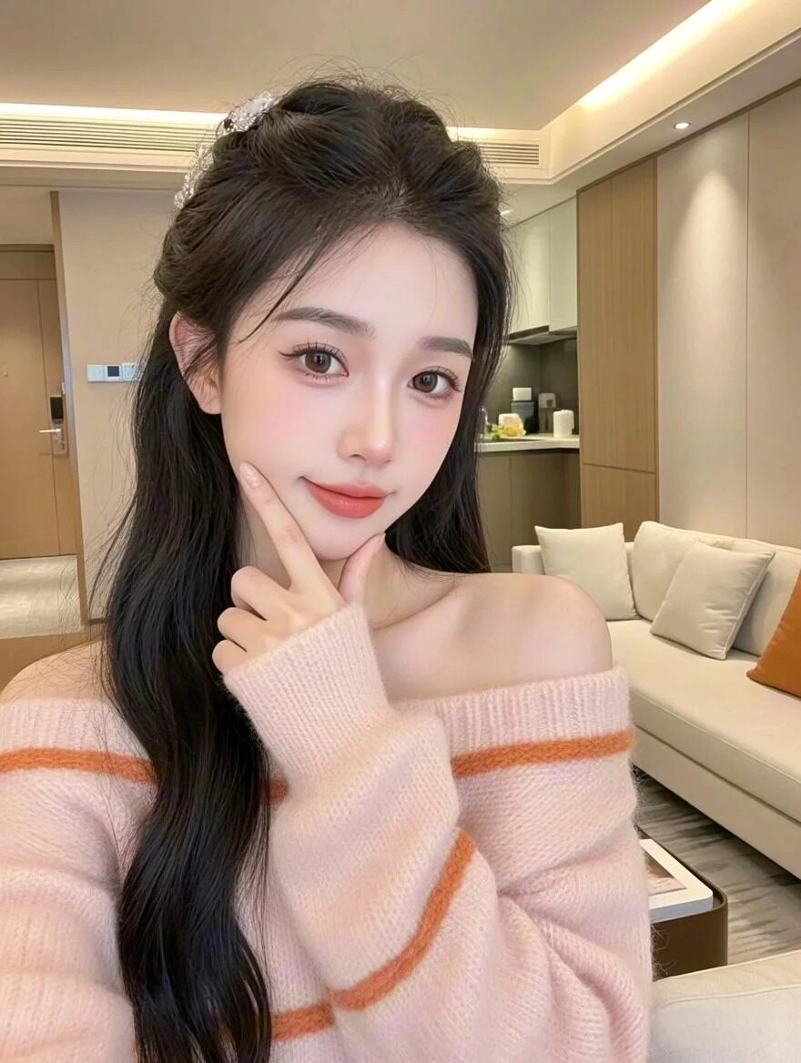 Áo len hồng phối cam, tóc xoăn buộc nửa đầu, thần thái nhẹ nhàng đầy nữ tính.