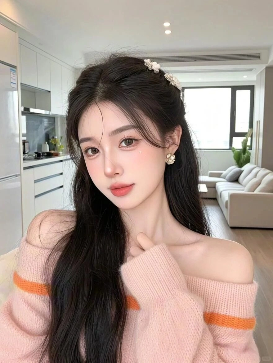 Kiểu tóc nửa buộc thanh lịch, áo len hở vai nhẹ nhàng, nét đẹp cuốn hút trong phòng.