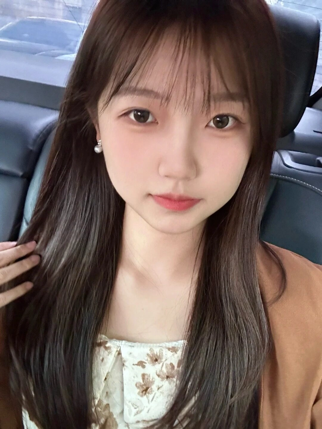 Tóc dài suôn mượt, váy hoa nhã nhặn, phong cách dịu dàng khi ngồi trong xe.