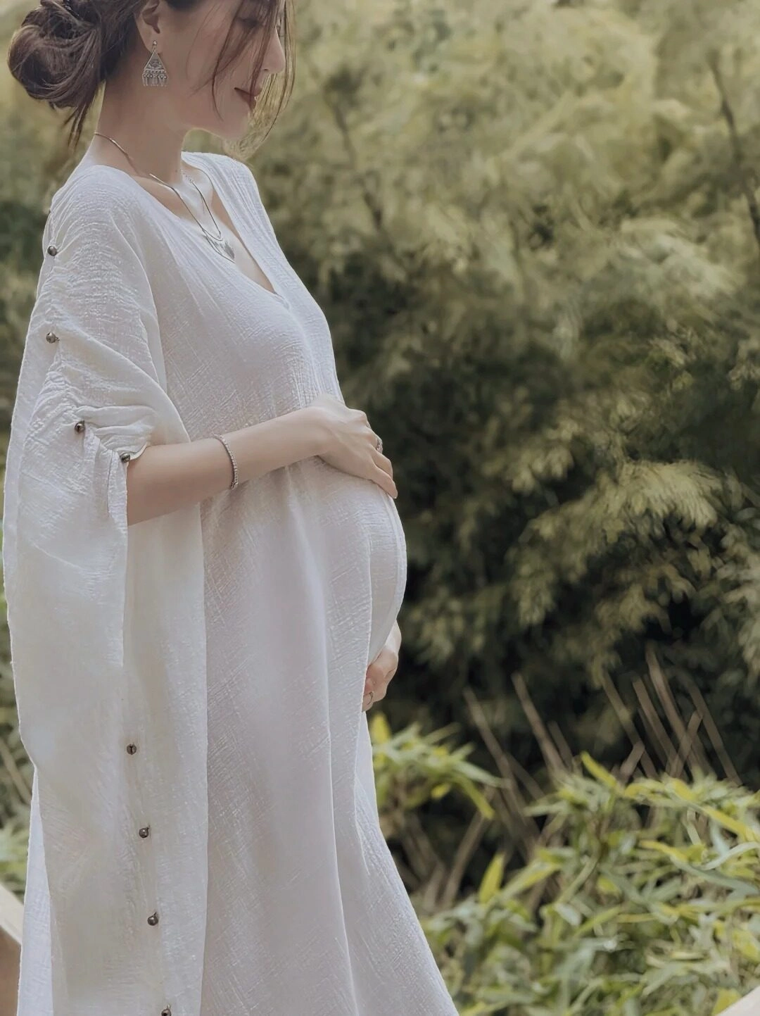Chiếc váy trắng dài rộng với hàng cúc tinh tế, mẹ bầu dịu dàng giữa thiên nhiên.
