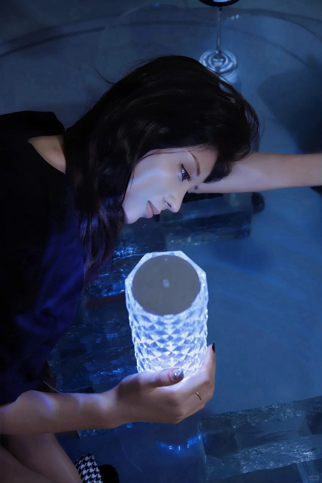 Ánh đèn xanh phản chiếu trên khuôn mặt, đôi mắt trầm tư chứa đầy tâm sự.