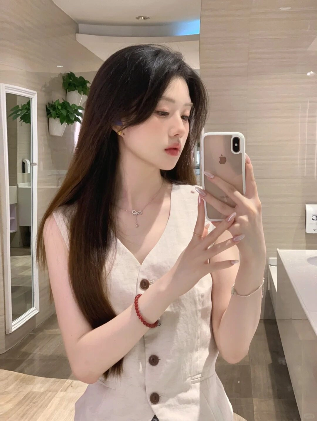 Tạo dáng chụp gương với kiểu tóc bồng bềnh tự nhiên, diện trang phục tối giản tinh tế.