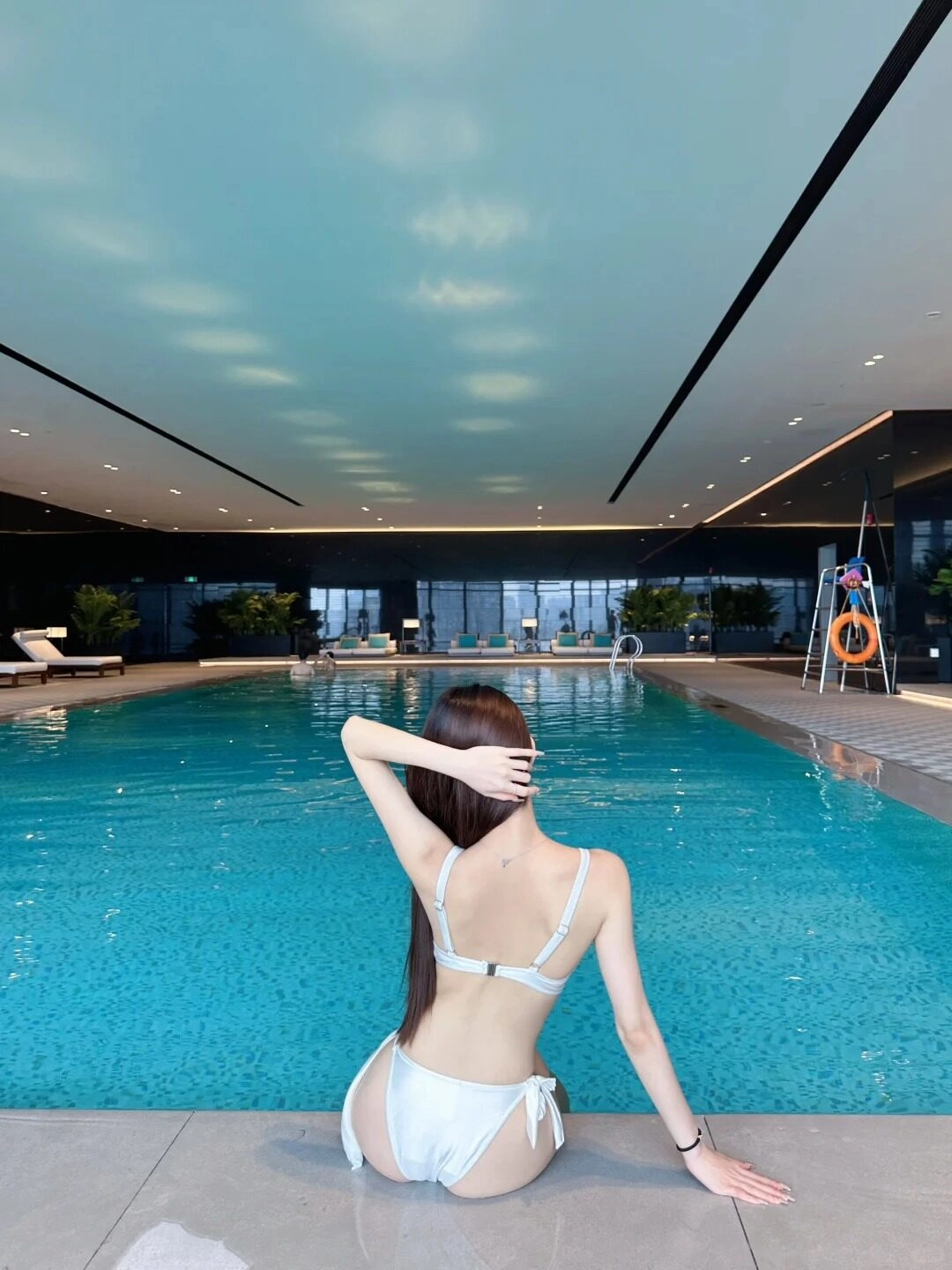 Tạo dáng uyển chuyển bên hồ bơi, mái tóc dài buông nhẹ càng thêm nữ tính.