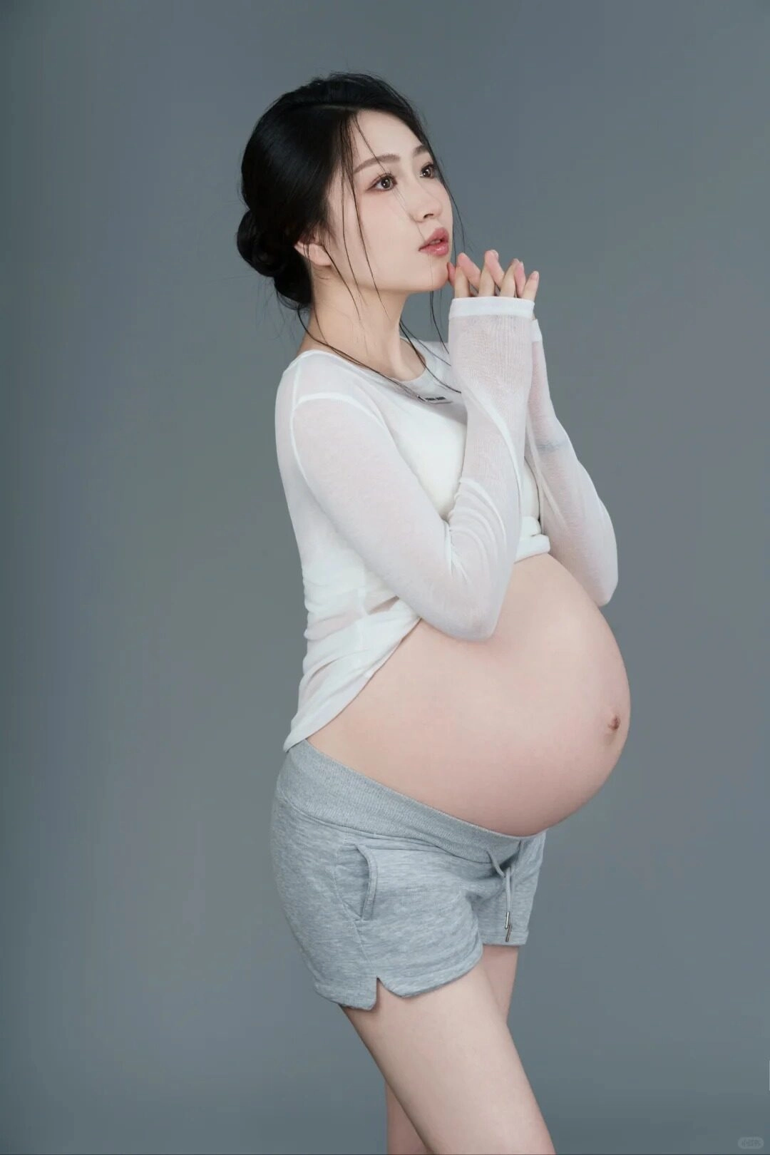 Mẹ bầu diện áo dài tay trắng xuyên thấu, chắp tay cầu nguyện cho thiên thần nhỏ.