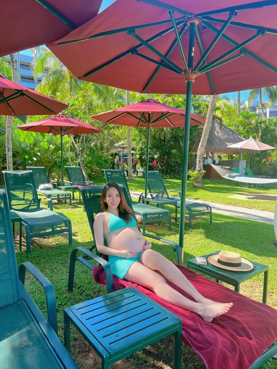 Nằm thư giãn dưới bóng dù, mẹ bầu diện bikini xanh, tận hưởng kỳ nghỉ tuyệt vời.