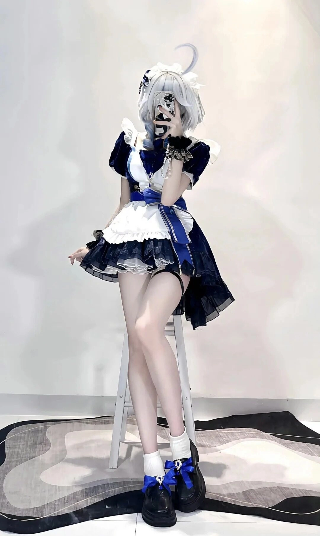 Trang phục xanh trắng đen cùng mái tóc bạch kim nổi bật.