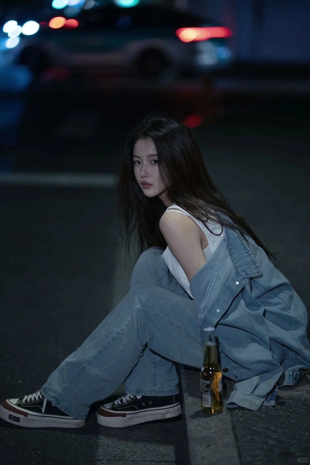 Ngón tay lướt vỏ chai bia, ánh mắt xa xăm giữa dòng xe vội vã.