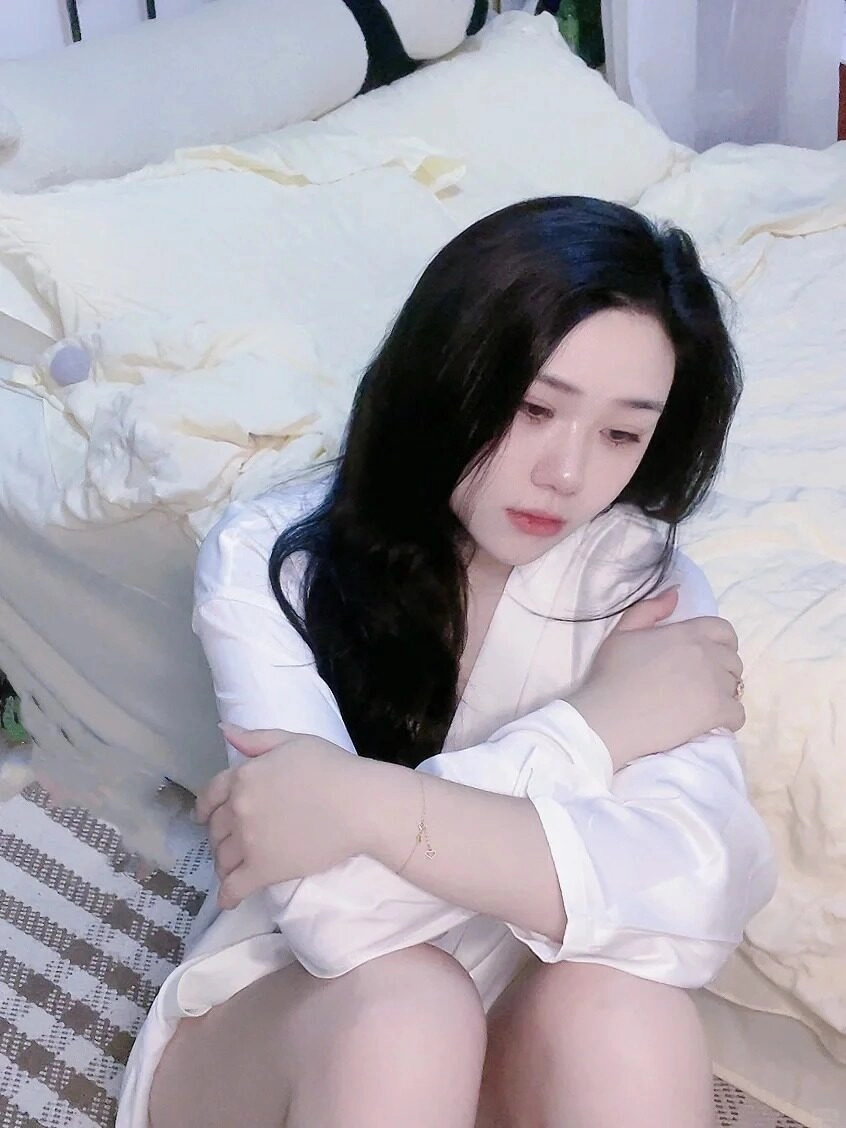 Áo sơ mi rộng ôm vai gầy, cô gái thu mình trong căn phòng lặng lẽ.