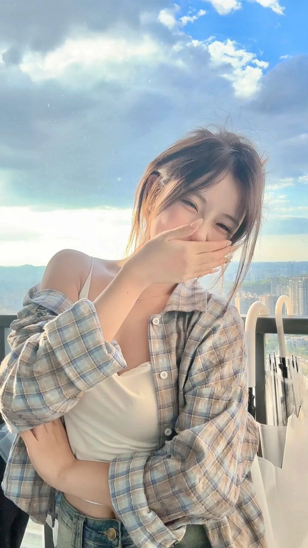 Nụ cười rạng rỡ dưới ánh nắng, sơ mi caro khoác hờ tạo vẻ ngoài năng động.