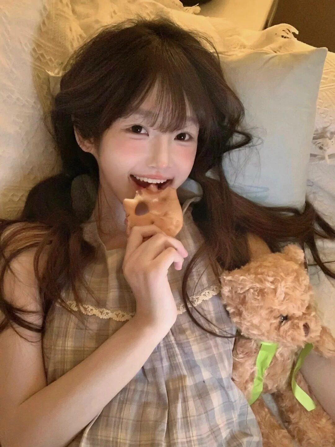 Nụ cười rạng rỡ, tóc buộc hai bên tinh nghịch cùng gấu bông đáng yêu.