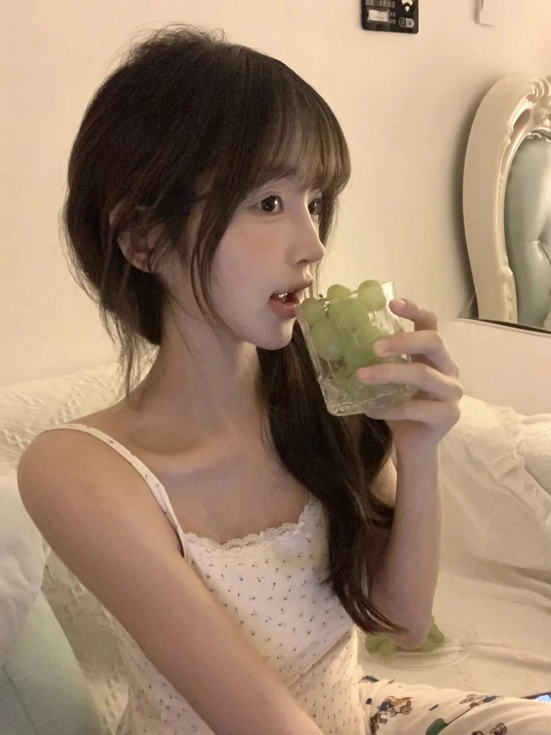 Nhấp nhẹ ly nho xanh, tóc buộc lệch tinh tế mang đến vẻ đẹp trong trẻo.