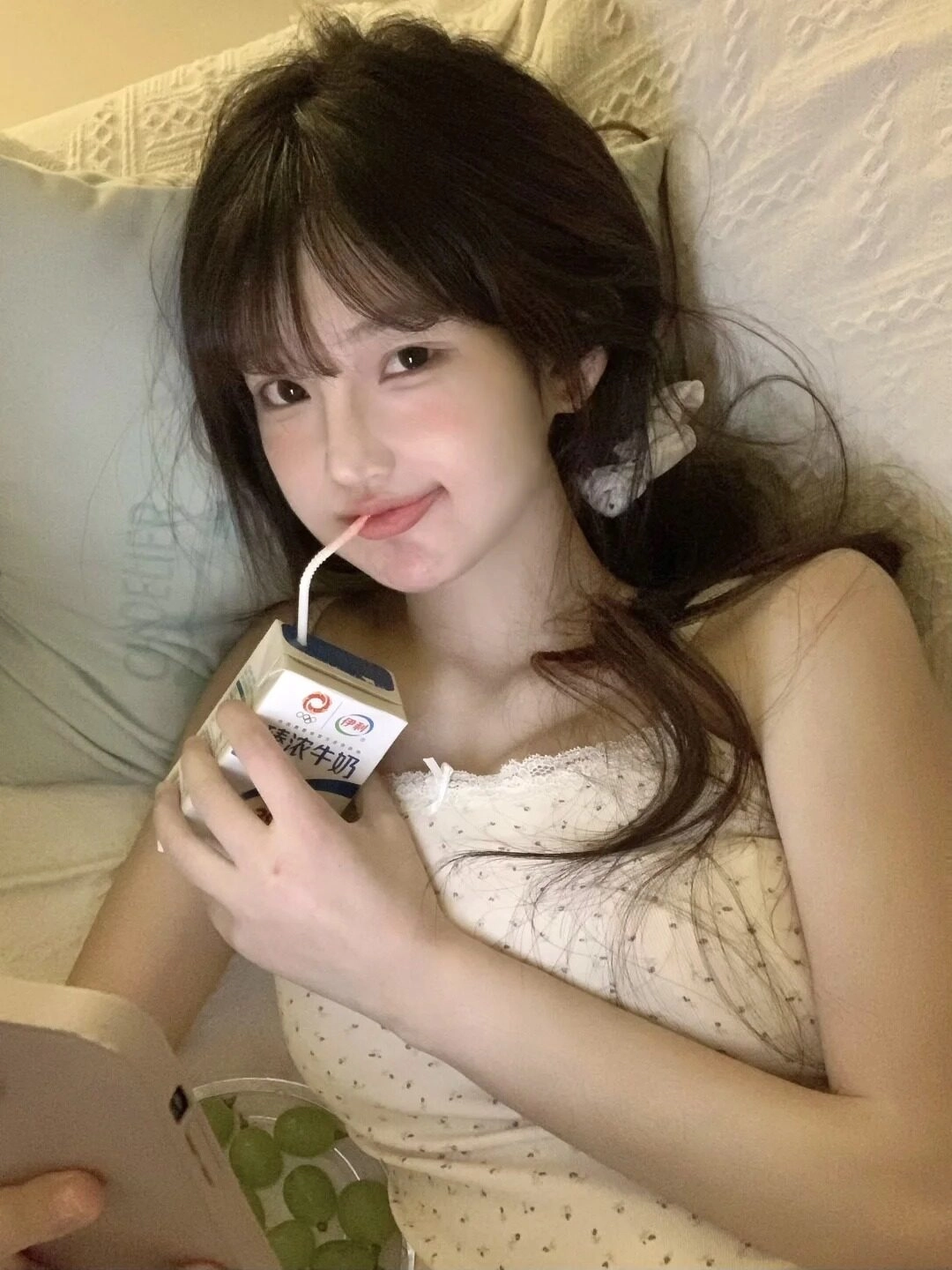 Nhẹ nhàng tựa đầu, uống sữa bằng ống hút với ánh mắt ngọt ngào thư giãn.