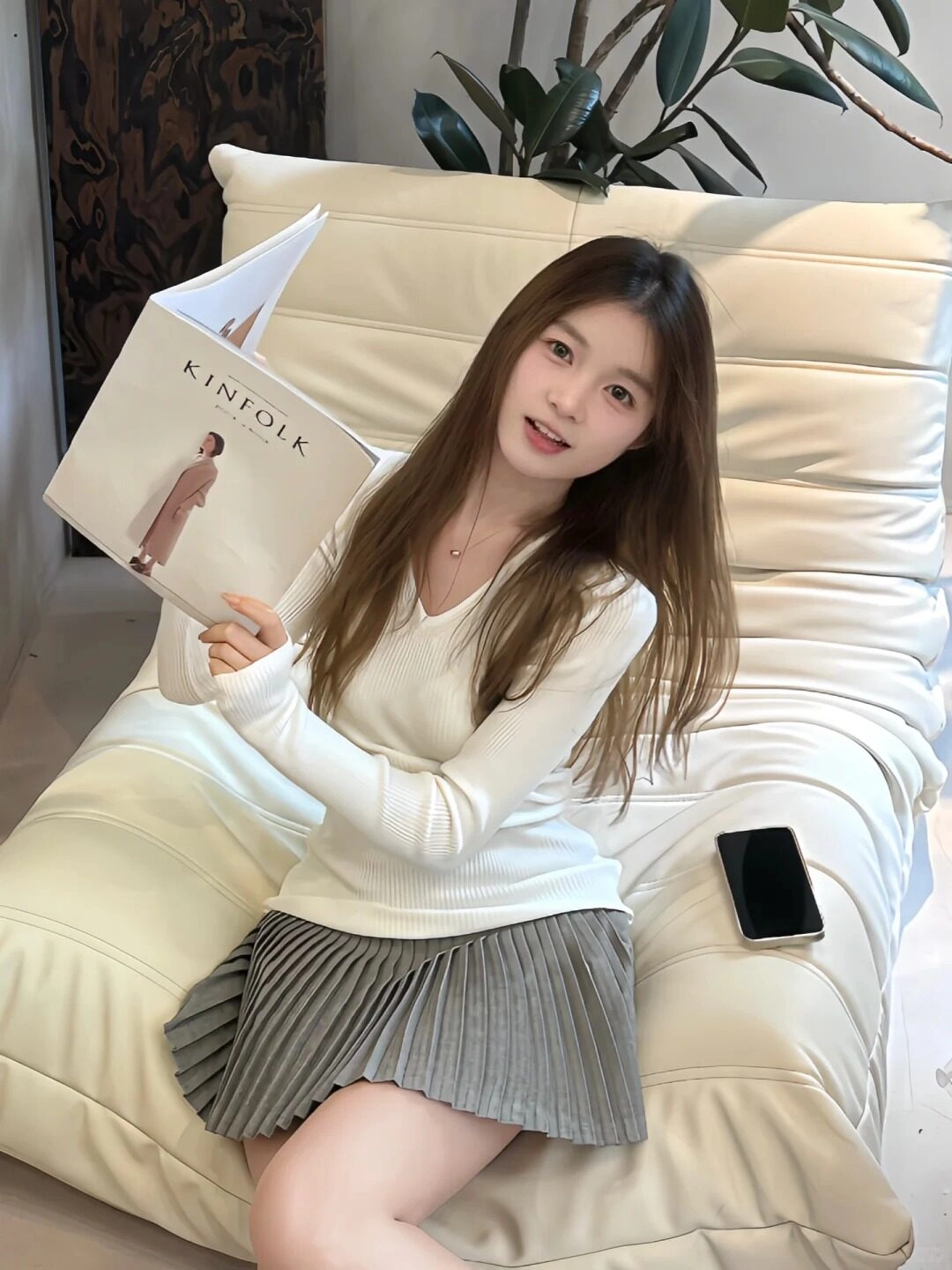 Tay cầm cuốn sách, cô gái trẻ xinh đẹp tươi cười tạo dáng