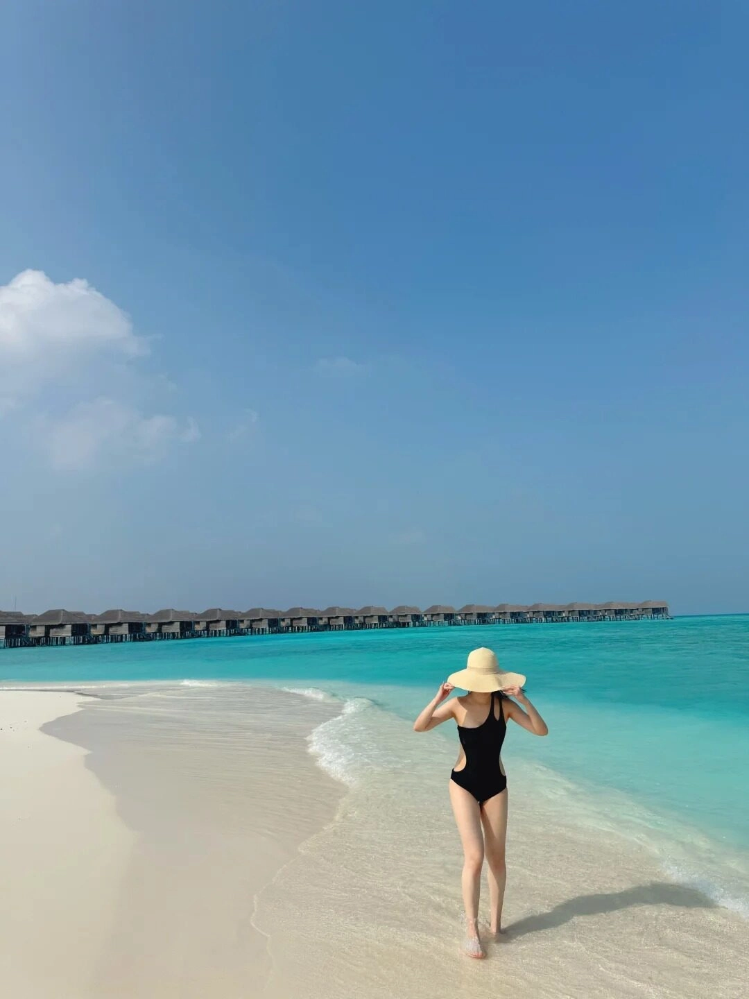 Dạo bước trên bãi cát trắng, bikini đen và mũ che nắng quyến rũ