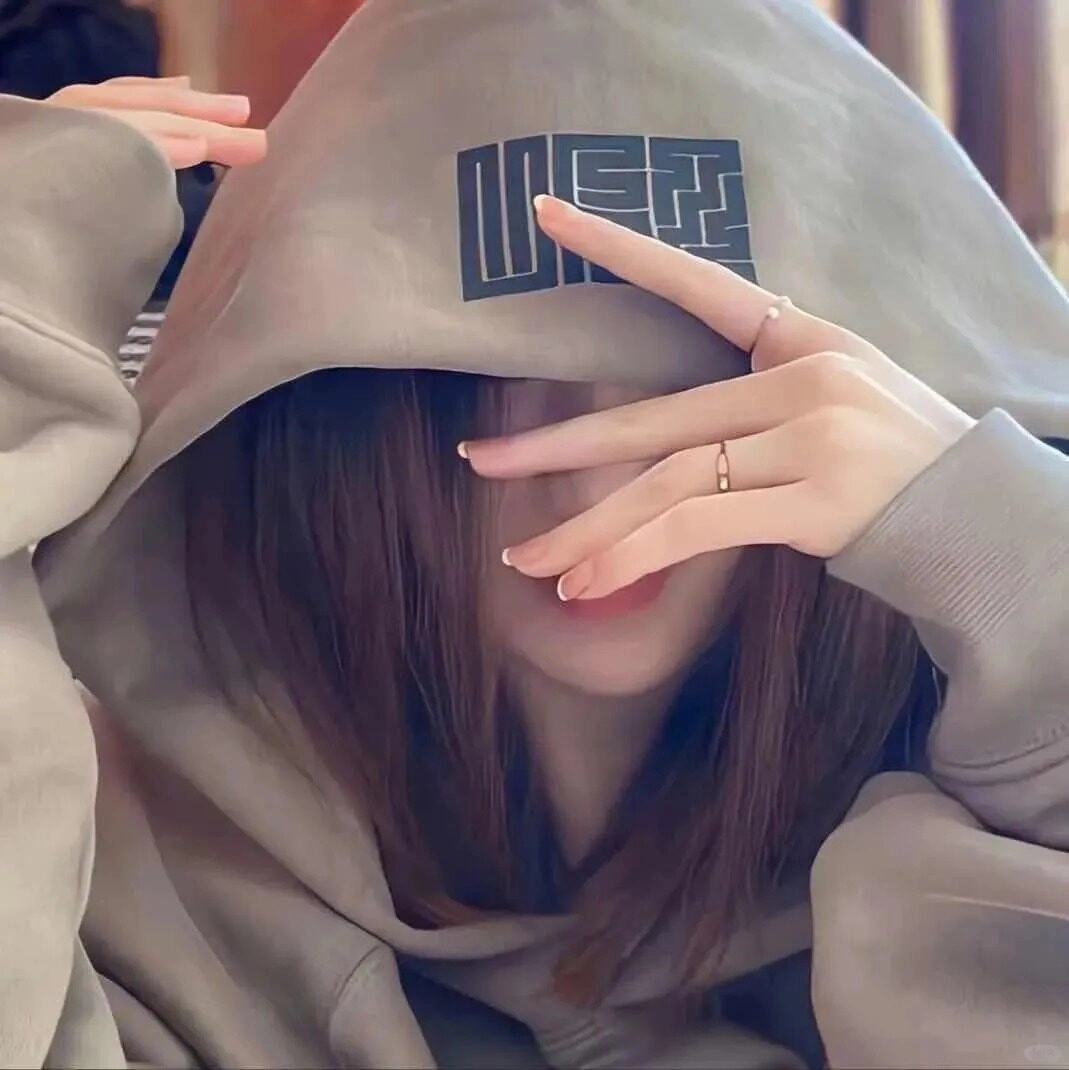 Cô gái mặt dưới áo hoodie xám, kiểu tóc xoăn tự nhiên đầy cá tính.