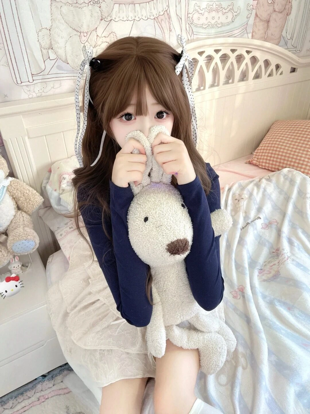 Cô nàng tóc nâu buộc nơ tinh nghịch, ôm gấu bông che mặt rất đáng yêu.