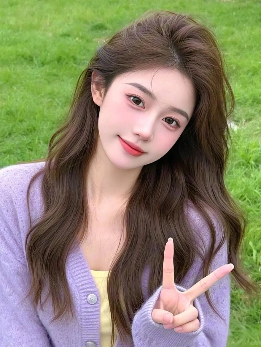 Áo len tím nhẹ nhàng kết hợp mái tóc xoăn dài, nụ cười dịu dàng.