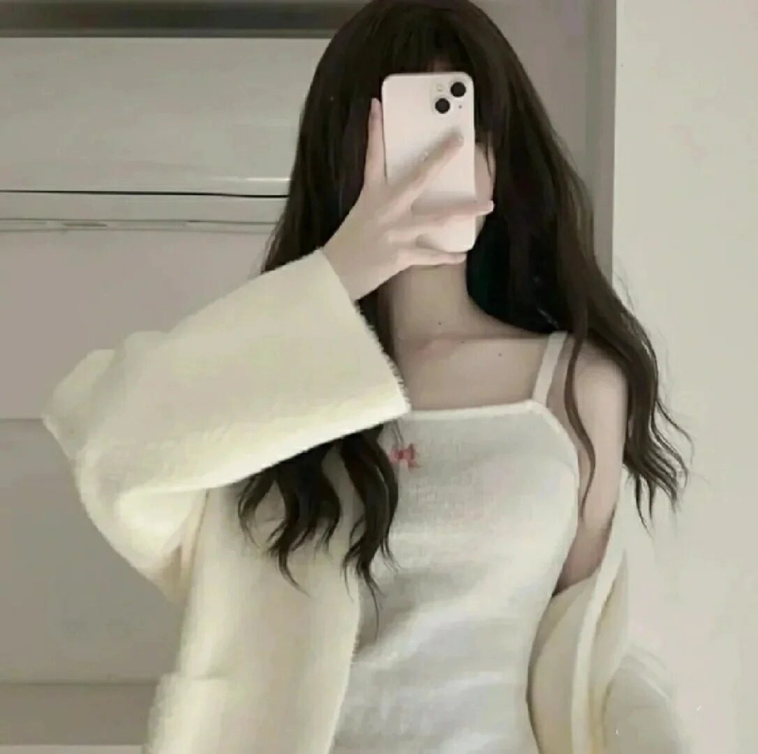 Che mặt với điện thoại, áo len trắng và tóc xoăn nhẹ nhàng