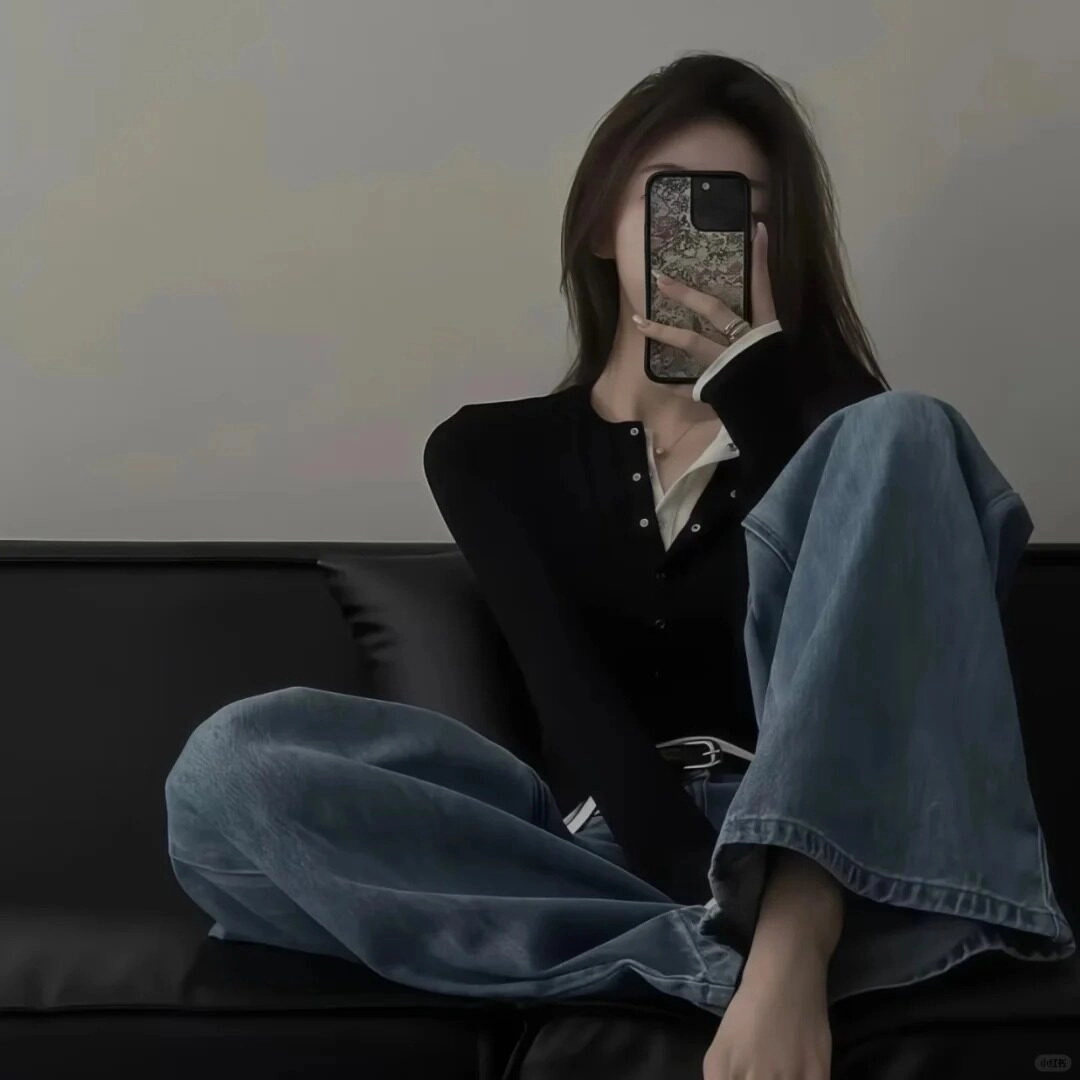 Giấu mặt sau điện thoại, diện áo đen cùng quần jeans ống rộng cực chất.