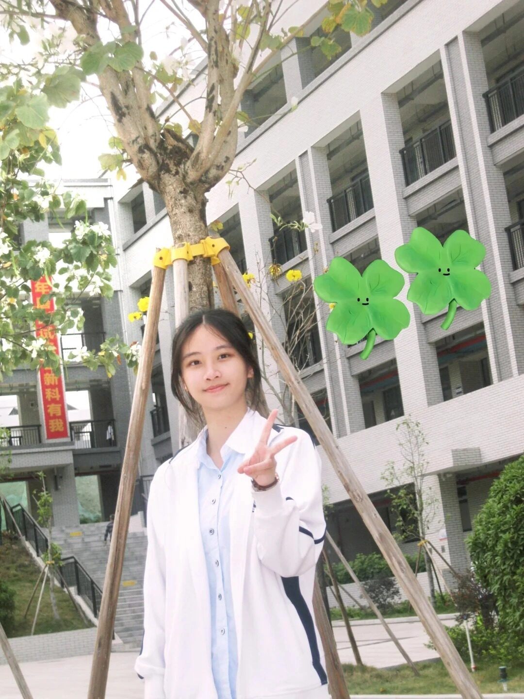  Nàng gái xinh tạo dáng bên cây cỏ, nụ cười dịu dàng cùng chiếc áo trắng.