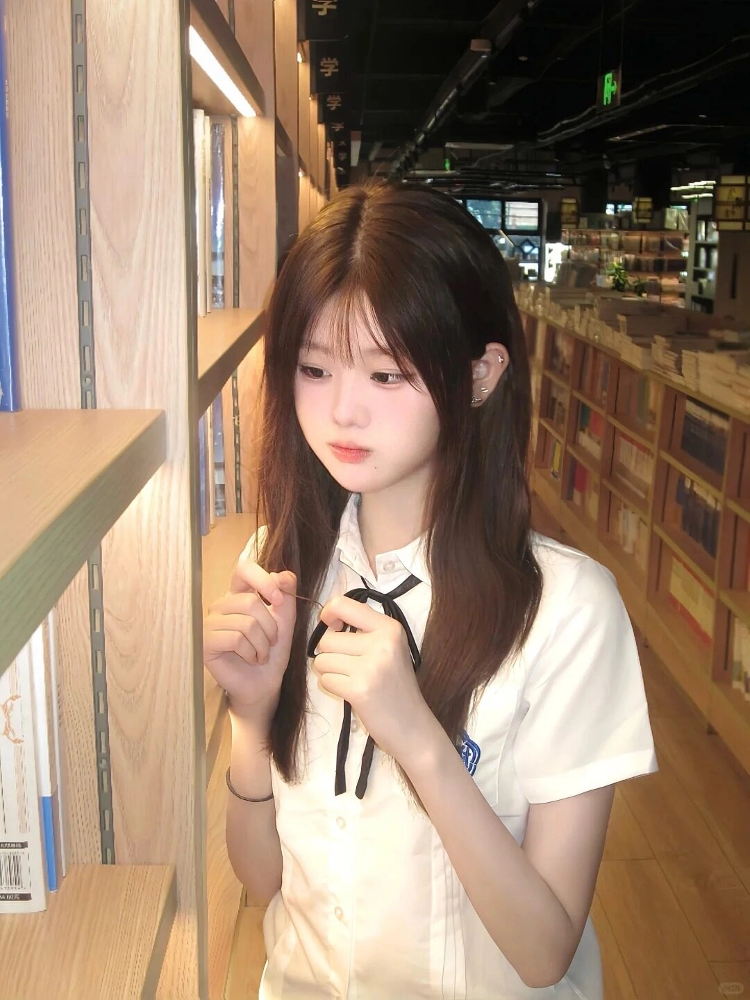 Cô gái trong đồng phục học sinh, mái tóc dài xõa nhẹ, ánh mắt trầm lắng