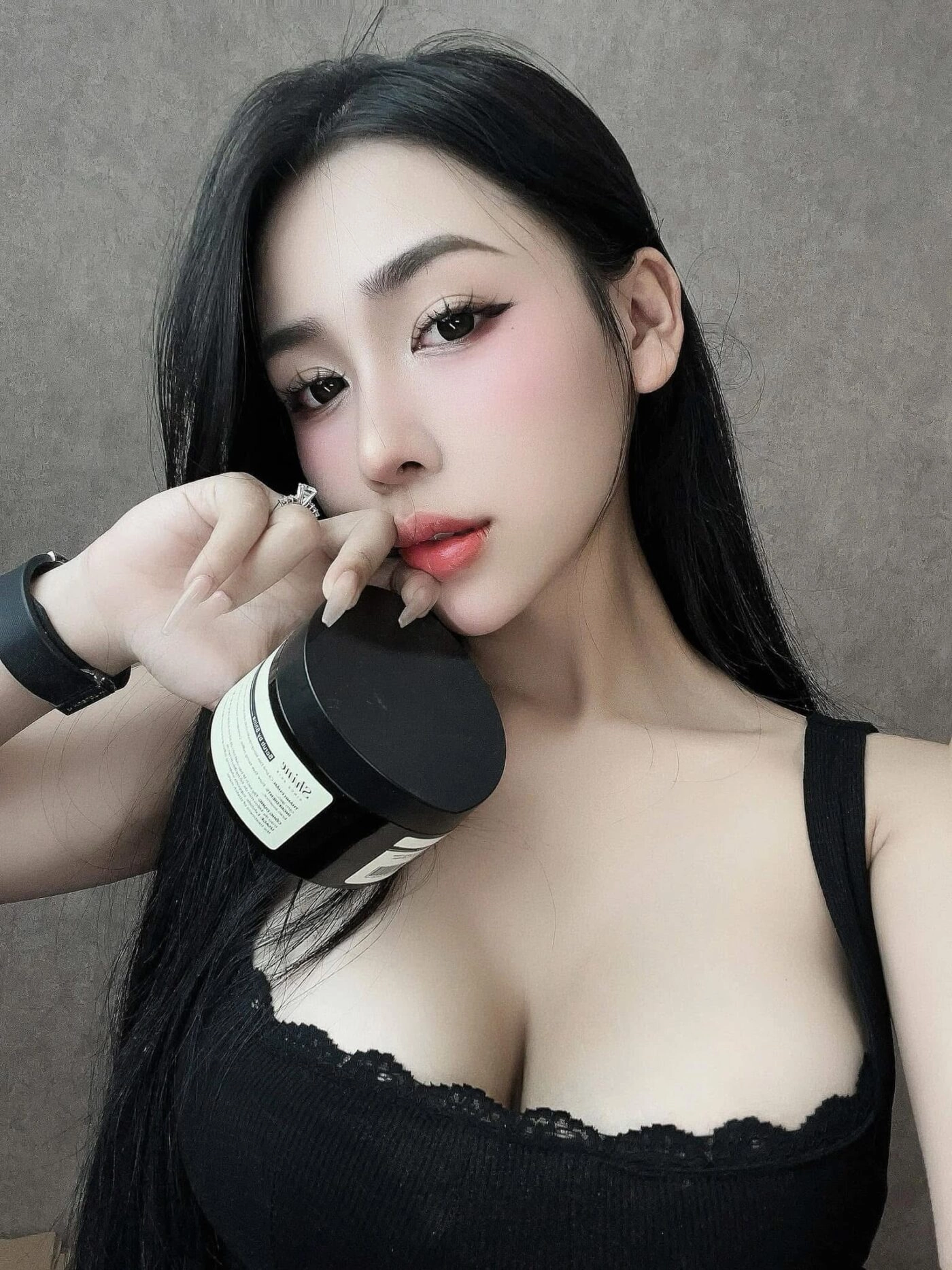 Áo đen tuyền, mái tóc đen dài và ánh mắt tinh tế sâu cuốn hút.