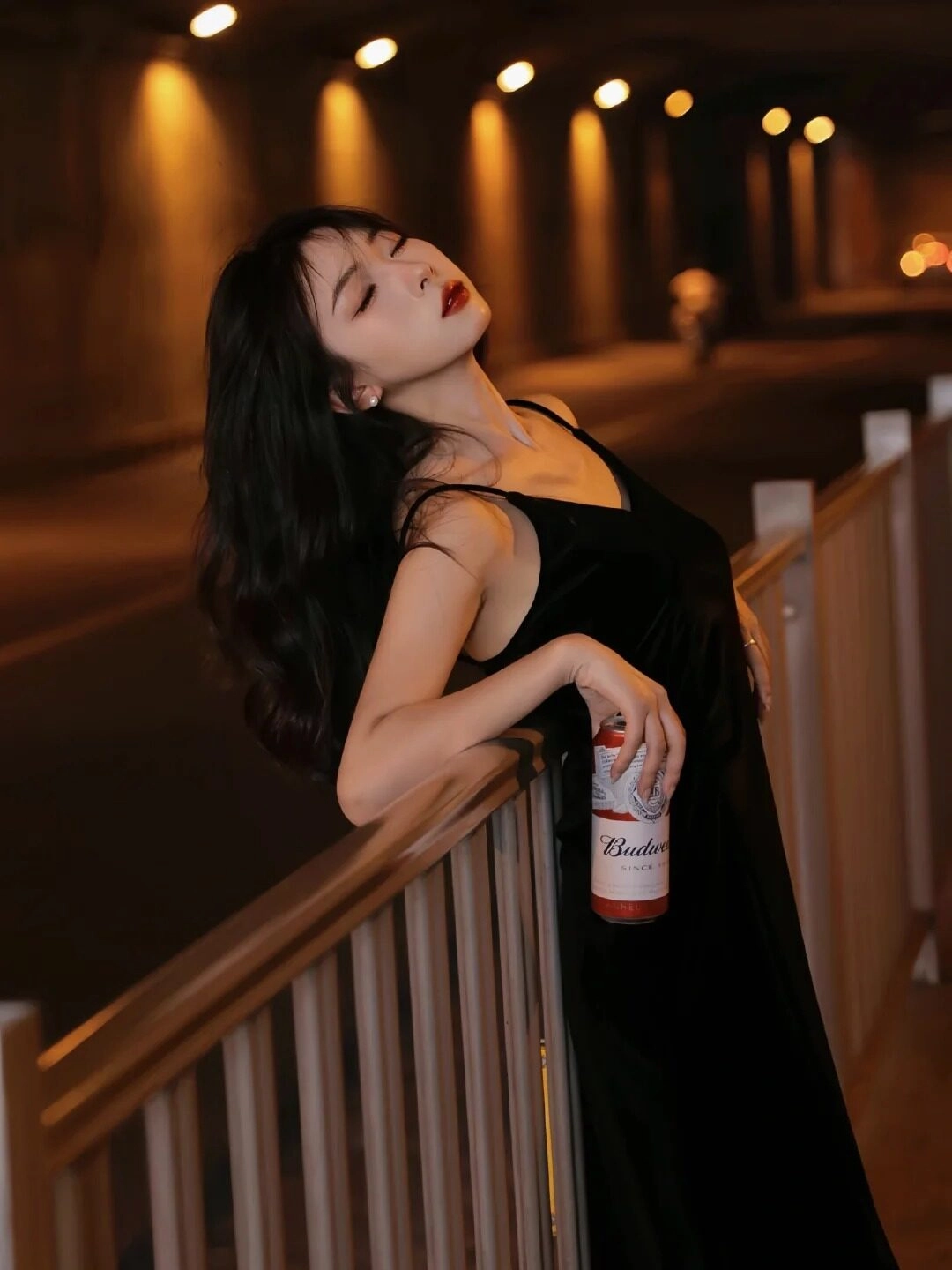 Nghiêng mình trong đêm tối, đôi môi khẽ mím lại, cô gái trông đầy cô đơn.