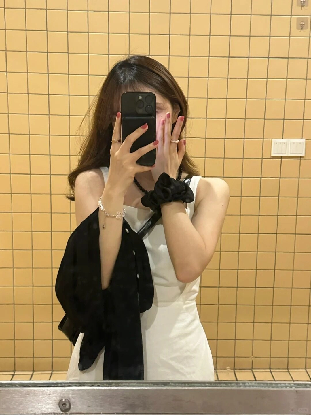 Che mặt bằng điện thoại, Váy trắng nhẹ nhàng, tay cầm áo khoác đen.