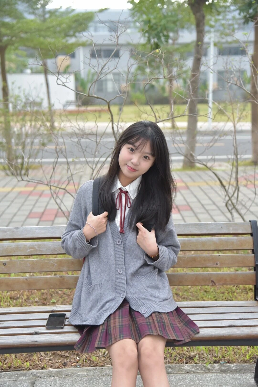 Ánh mắt ngây thơ, phong cách nữ sinh dịu dàng bên ghế đá sân trường.
