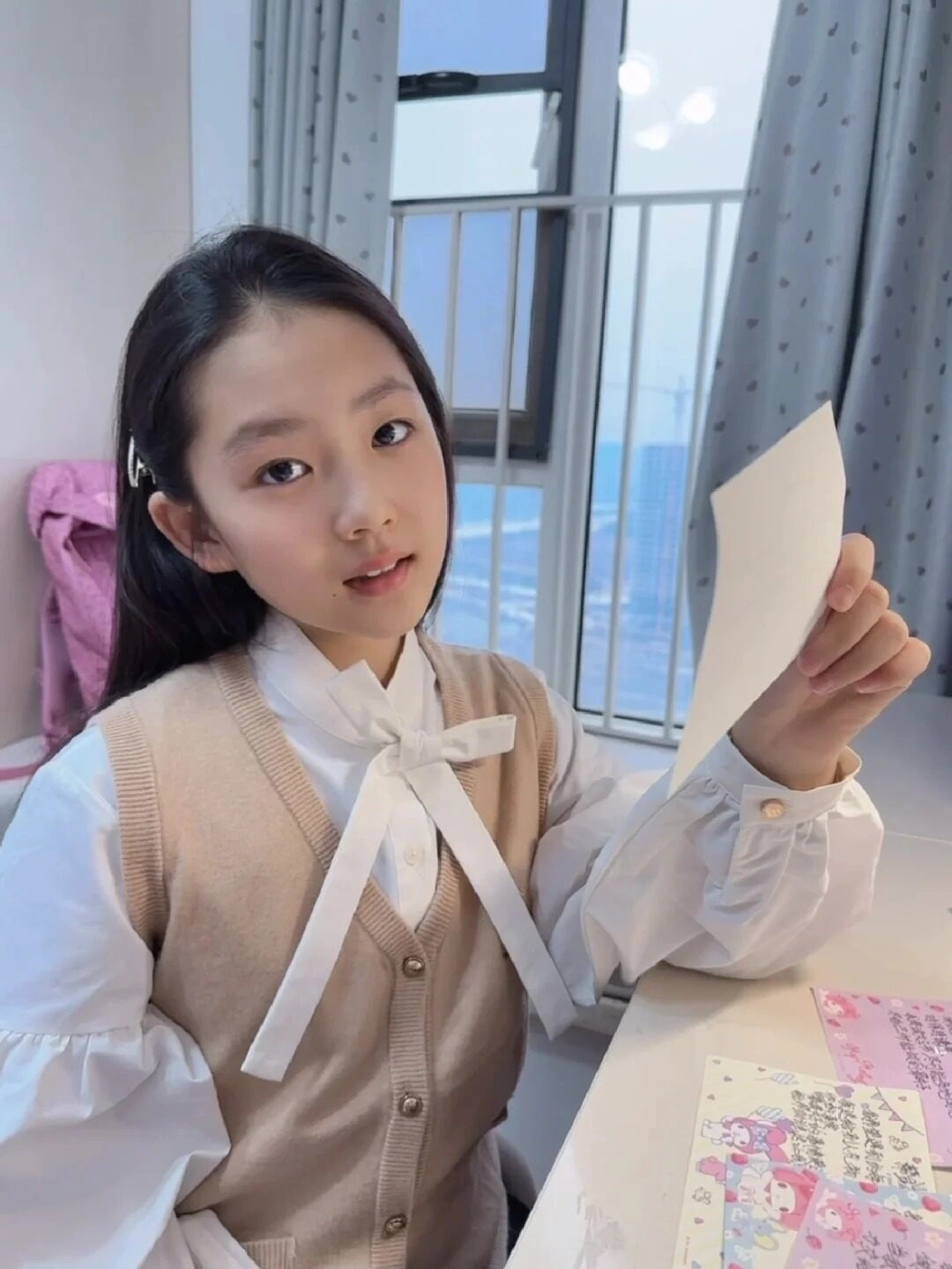 Nét mặt dịu dàng, cô bé chăm chú đọc thư bên khung cửa sổ.