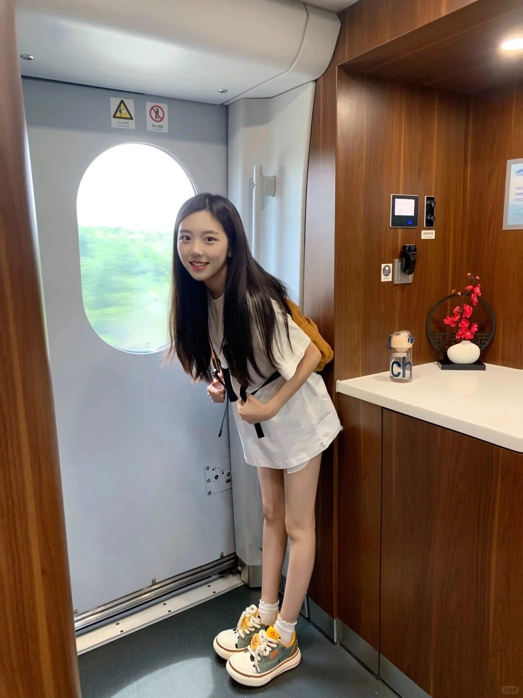 Em gái vui vẻ chuẩn bị bước xuống tàu, nét tươi xinh rạng rỡ.