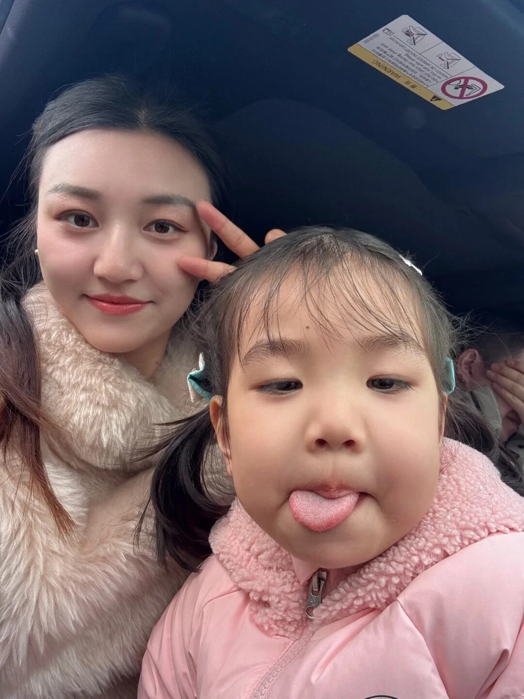 Con gái thè lưỡi tinh nghịch, mẹ cười vui vẻ bên nhau.