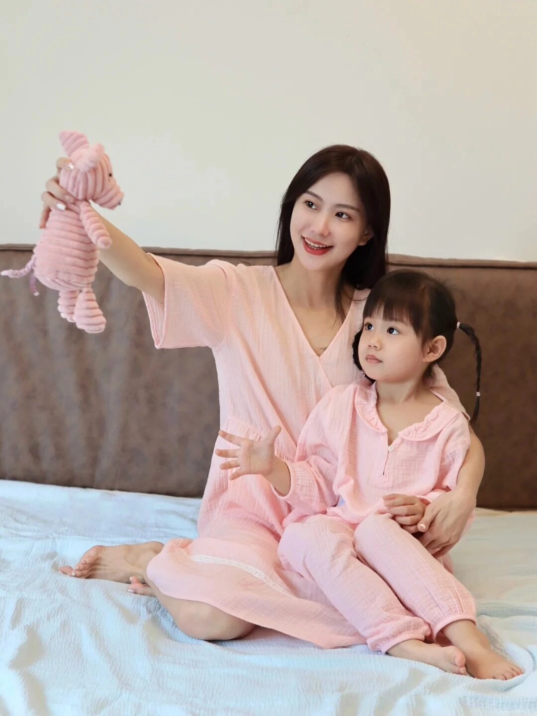 Hai mẹ con diện đồ ngủ hồng, nụ cười ngọt ngào, ấm áp.