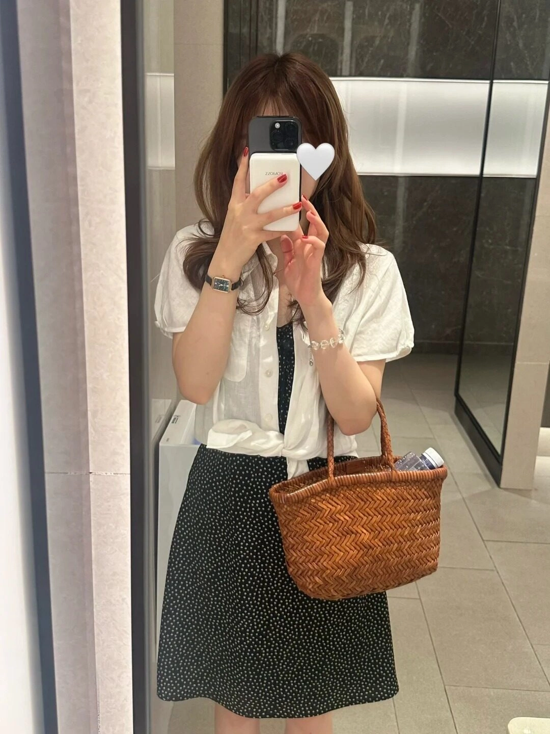 Váy hoa nhẹ nhàng, trắng áo gió nhẹ, túi xách đám mây chụp trước khung.