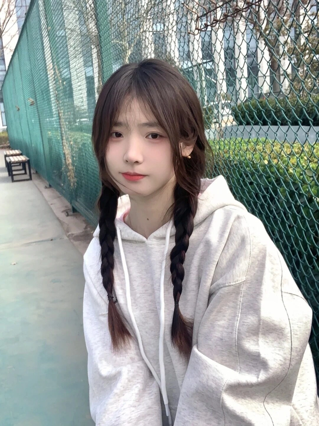 Mái tóc tết hai bên cùng hoodie xám tạo vẻ ngoài đáng yêu khó cưỡng.