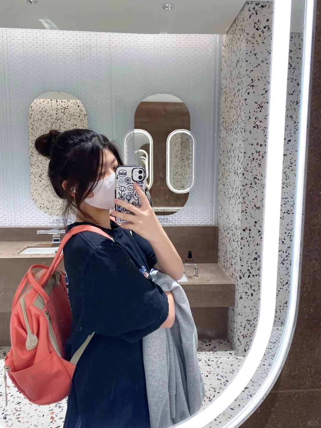 Góc nghiêng thu hút trong gương, búi tóc năng động, trẻ trung cá tính.