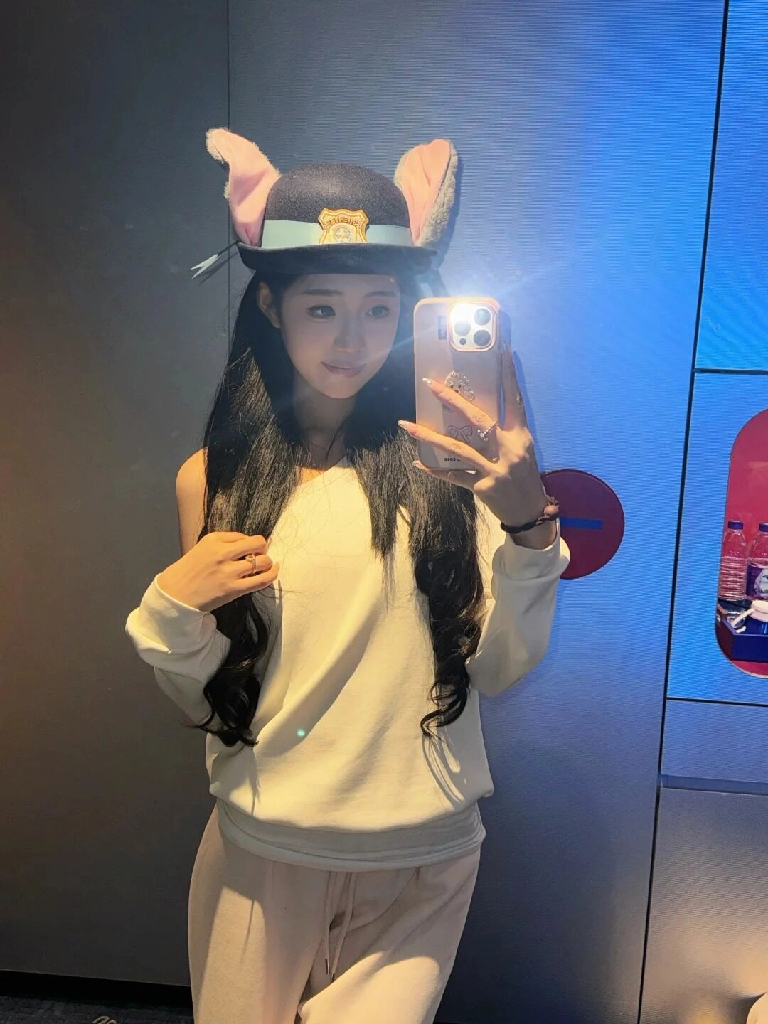 Đội mũ tai thú đáng yêu, tóc dài xoăn, biểu cảm dễ thương vui tươi.