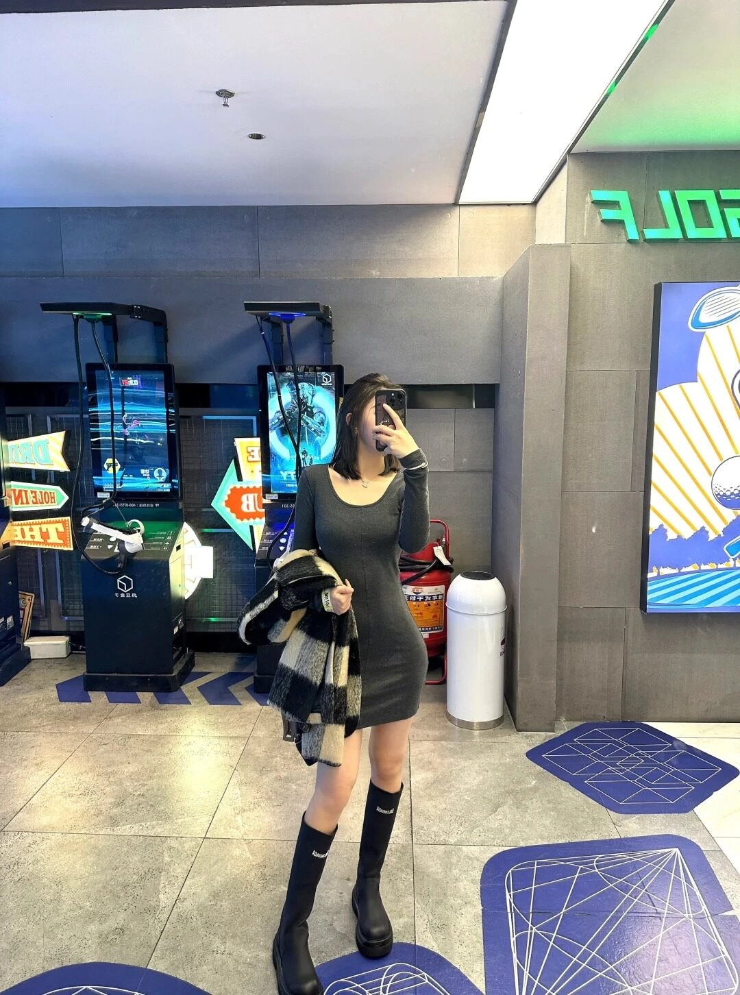 Váy ngắn ôm sát, bốt cao cổ, phong cách cá tính nổi bật.