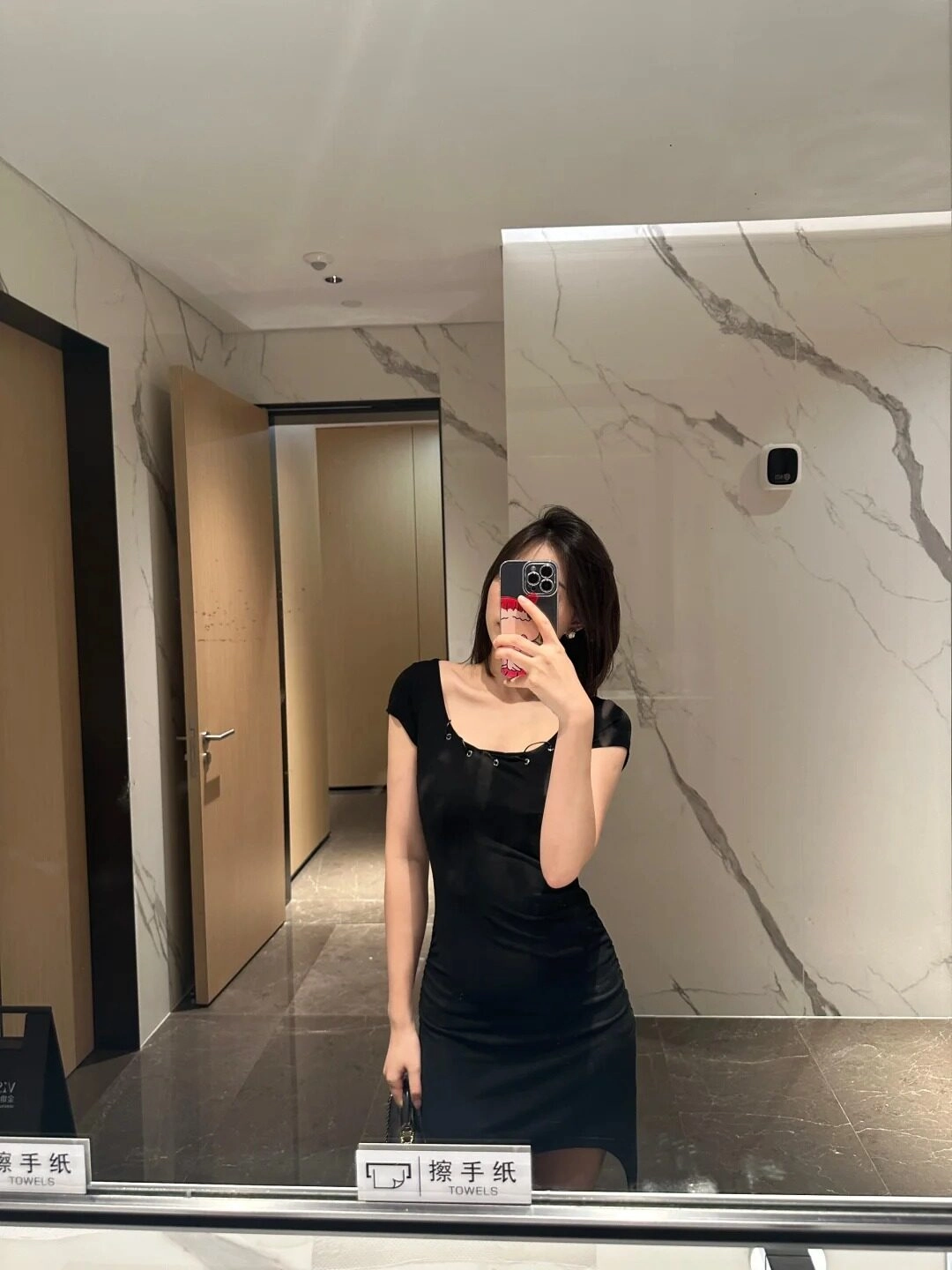 Váy đen ôm quyến rũ, selfie nghiêng đầu nhẹ nhàng trong phòng tắm.