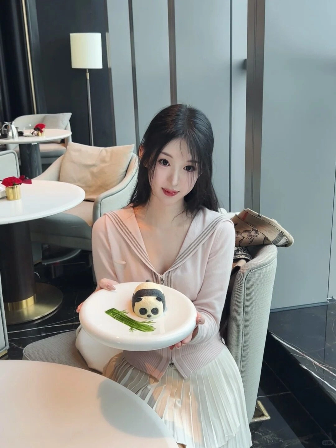 Mỹ nhân váy hồng, cầm bánh panda dễ thương, nụ cười mĩm trên môi.